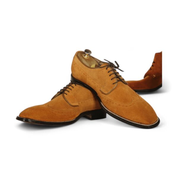 Expertly crafted with a hand-stitched design, these stylish men's tan wing tip lace-up shoes are a must-have for any fashion-forward gentlemen. Made from high-quality suede, these designer shoes offer both style and comfort, making them the perfect addition to any wardrobe.